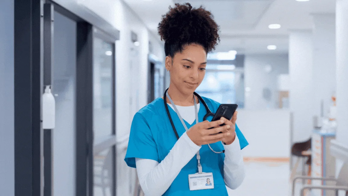 Nurse looking at phone and smiling